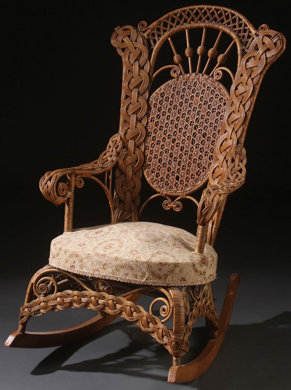 A GOOD LATE VICTORIAN WOVEN WICKER ROCKER: A GOOD LATE VICTORIAN WOVEN WICKER ROCKER. The woven oval medallion back panel supported by stick and ball fan work and overlapping scrolled panels above an upholstered seat raised on an arched panel 