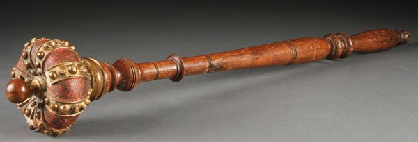 A CARVED AND POLYCHROME WOOD SCEPTER, 19TH C: A CARVED AND POLYCHROME WOOD SCEPTER, 19TH CENTURY. The elongated turned walnut handle surmounted with a crown shaped finial finished in ruby colored lacquer and gilt. Length 25 inches (63.5 cm).
