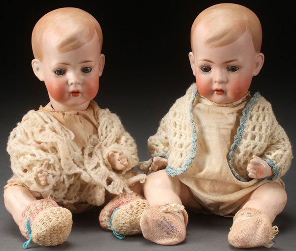 A PAIR OF BRUNO SCHMIDT GERMAN BISQUE DOLLS: A PAIR OF BRUNO SCHMIDT GERMAN BISQUE DOLLS, CIRCA 1900. Of twin toddlers with bisque socket heads, set blue eyes, open mouths with teeth and felt tongues on jointed compo bodies, impressed BSW marks.