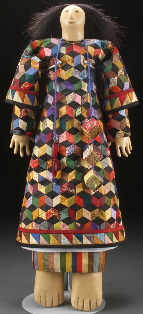 A CHARLA KHANNA NATIVE AMERICAN ARTIST DOLL: A CHARLA KHANNA NATIVE AMERICAN ARTIST DOLL, 20TH CENTURY. Of large proportion with hand sculpted composition head, hands and feet, hand painted features and applied horse hair dressed with a patchwor