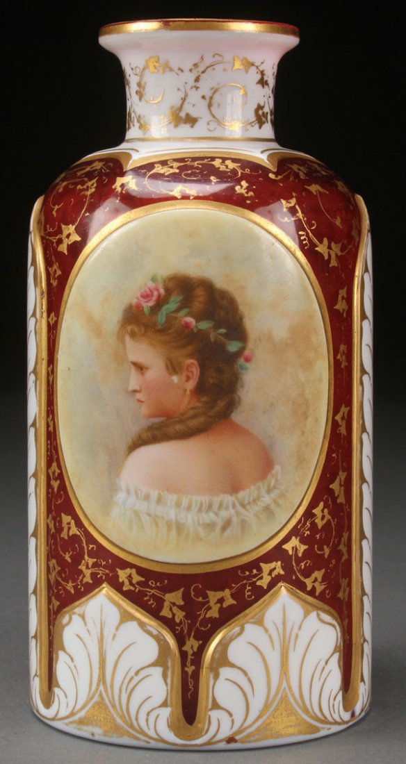 A FINE BOHEMIAN HAND PAINTED GLASS PORTRAIT: A FINE BOHEMIAN HAND PAINTED GLASS PORTRAIT BOTTLE, CIRCA 1865. In cranberry colored glass overlaid with white opaque and cut back with a design of elongated banana leaves framing an oval enameled po