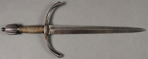 A FINE STEEL LEFT HANDED PARRYING DAGGER: A FINE STEEL LEFT HANDED PARRYING DAGGER. Double edged triangular tapering blade with slightly forward canted drooping quillons with lobed ends, wire wrapped wooden handle with substantial draped pomm