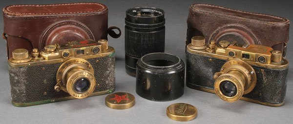 RUSSIAN SOVIET LEICA CAMERAS: A PAIR OF RUSSIAN SOVIET PERIOD MADE COPIES OF LEICA CAMERAS. Including one bearing German WWII marks and one marked in Russian "Stalin model". Together with their custom-fitted leather cases and a sc