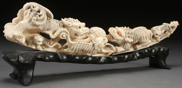 CHINESE CARVED IVORY TUSK, CIRCA 1925: A FINE CHINESE CARVED IVORY TUSK, CIRCA 1925. Depicting a scene of five playful Foo lions each with inset colored glass or stone eyes and fully carved in the round with good detail. Length 15.5 inches