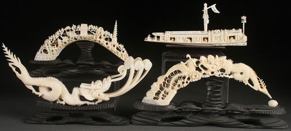 FOUR CHINESE CARVED IVORY TUSKS, CIRCA 1930s: A GROUP OF FOUR CHINESE CARVED IVORY TUSKS, CIRCA 1930s. Comprising a carved boars tusk "water dragon" with detailed scaling, a carved boars tusk "dragon and phoenix", a carved boars tusk "miniature v
