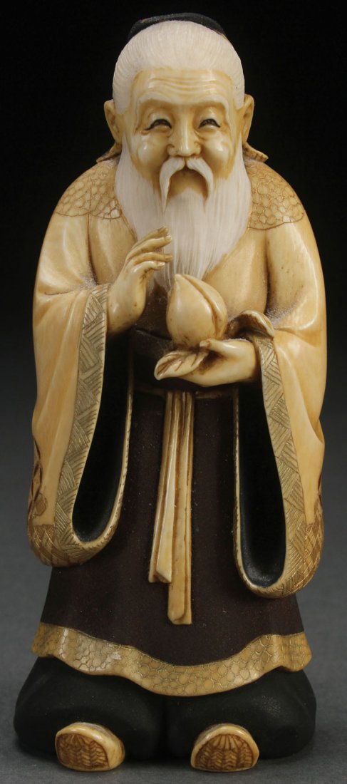 A VERY FINE JAPANESE CARVED IVORY OKIMONO: A VERY FINE JAPANESE CARVED IVORY OKIMONO, PROBABLY MEIJI PERIOD. Finely carved as a Buddhist monk with peach and decorated in matte brown and black with red enamel and gilt accents. The base with ins