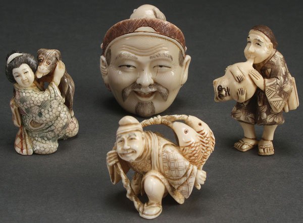 FOUR FINE JAPANESE CARVED IVORY NETSUKES, MEIJI: FOUR FINE JAPANESE CARVED IVORY NETSUKES, MEIJI PERIOD. Each well carved depicting a Geisha with puppy, a figure hiding behind a large Kabuki mask, a man inflating a cat shaped balloon and a fisherman