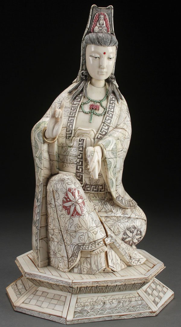 A CHINESE CARVED BONE AND IVORY KWAN-YIN: A CHINESE CARVED BONE AND IVORY KWAN-YIN. Depicted in seated form on a double lotus throne with incised and polychrome decorated garments. Height 16.75 inches (42.5 cm). The offered lot is accompanied