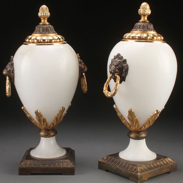 PR OF CONTINENTAL CARVED ALABASTER URNS: A PAIR OF CONTINENTAL CARVED ALABASTER AND GILT BRONZE MOUNTED DECORATIVE URNS, 20TH CENTURY. Of ovoid form in semi-translucent alabaster, raised on alabaster and bronze pedestal bases. The shoulder s