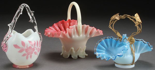 A COLLECTION OF THREE VICTORIAN ART GLASS BASKETS: A COLLECTION OF THREE VICTORIAN ART GLASS BASKETS. Comprising a Steven & Williams cameo glass opalescent basket with thorn handle, a blue cased basket with bronze mounted handle and a cased glass bask