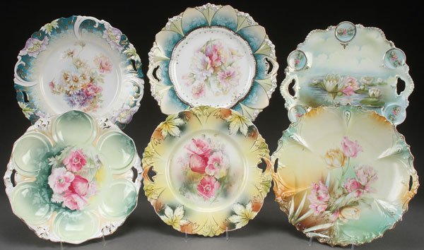 SIX R.S. PRUSSIA & GERMANY PORCELAIN CAKE PLATES,: SIX R.S. PRUSSIA AND GERMANY CAKE PLATES, CIRCA 1900. Various molds including floral, medallion and various decoration including waterlily. Largest diameter 11.25 inches (28.5 cm).