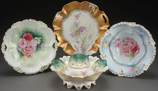4 R.S. PRUSSIA PORCELAIN BOWLS AND CAKE PLATES: FOUR FINE R.S. PRUSSIA BOWLS AND CAKE PLATES, CIRCA 1900. Comprising a mold 152 handled low bowl, a lilies of the valley “Hidden Image” handled cake plate with “Tiffany” finish, a “Lilly” 