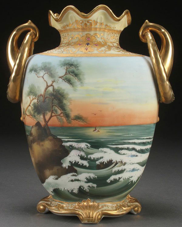 A LARGE HAND PAINTED NIPPON SCENIC DECORATED VASE: A LARGE HAND PAINTED NIPPON SCENIC DECORATED VASE, EARLY 20TH CENTURY. With scrolled ring handles flanking a jeweled rim, above a hand painted seascape sunset with crescending waves. Green M in wreat
