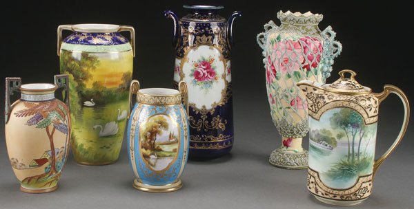 A SIX PIECE GROUP OF HAND PAINTED NIPPON PORCELAIN: A SIX PIECE GROUP OF HAND PAINTED NIPPON PORCELAIN, EARLY 20TH CENTURY. Comprising a cottage scene handled vase with Moriage trees, a two handled vase with swans, a cobalt and floral decorated vase, a
