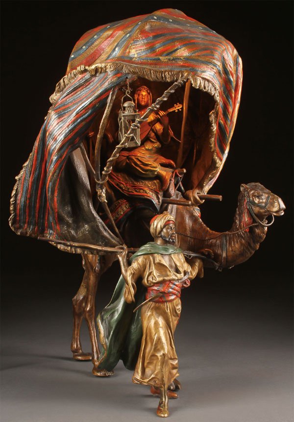 FRANZ BERGMAN ORIENTALIST COLD PAINTED BRONZE: AN EXCEPTIONAL FRANZ BERGMAN COLD PAINTED ORIENTALIST BRONZE LAMP, AUSTRIA, CIRCA 1900. Configured as a nomad with musket, leading a camel mounted with a beautiful odalisque playing a stringed instrum