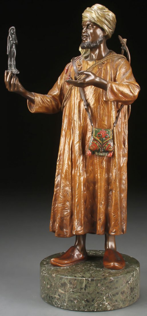 LARGE COLD PAINTED AUSTRIAN BRONZE OF ARAB: A VERY FINE COLD PAINTED AUSTRIAN BRONZE OF AN ARAB ANTIQUITIES SELLER, CIRCA 1900. Finely modeled in full round, of good proportions and anatomy, the figure offering an ancient Egyptian effigy and co