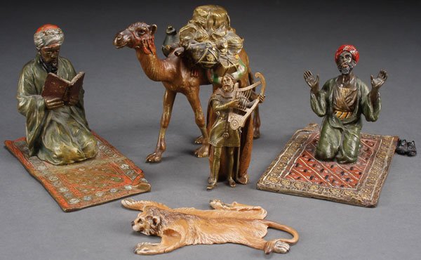 GROUP OF COLD PAINTED AUSTRIAN BRONZES CIRCA 1900: A GROUP OF COLD PAINTED AUSTRIAN BRONZES, CIRCA 1900. Comprising two men on rugs, one reading the Quran, the other in an attitude of prayer, the second with Bergman foundry mark. Together with a pack 