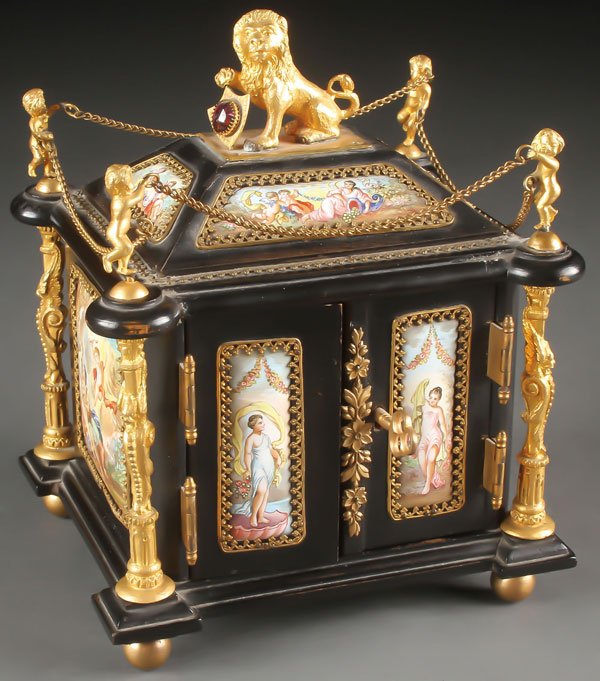 VIENNESE ENAMEL MINIATURE CHEST 19TH CENTURY: A FINE VIENNESE ENAMEL AND ORMOLU MOUNTED MINIATURE CHEST, 19TH CENTURY. Resting on four gilt ball feet, the ebonized wood carcass set at each corner with a gilt bronze column mounted with a winged gr