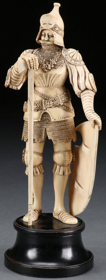 A FINELY CARVED IVORY FIGURE OF A STANDING KNIGHT: A FINELY CARVED IVORY FIGURE OF A STANDING KNIGHT, PROBABLY GERMAN, CIRCA 1890. Carved in full round with excellent relief carved details wearing armor and chainmail, his left hand holding a shield an