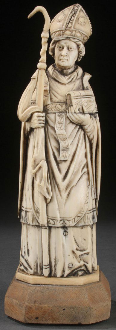 A FINELY CARVED IVORY FIGURE OF A BISHOP SAINT: A FINELY CARVED IVORY FIGURE OF A BISHOP SAINT, FRENCH, 19TH CENTURY. Carved in full round, of good proportions and anatomy, with deep folds and flowing robes, resting on a later wood plinth. Verso ne