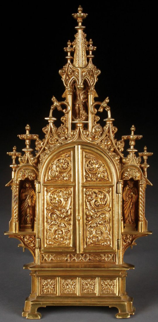 A GOTHIC STYLE POLISHED BRONZE TRIPTYCH RELIQUARY: AN ORNATE GOTHIC STYLE POLISHED BRONZE TRIPTYCH RELIQUARY FRAME, FRENCH, 19TH CENTURY. The impressive structure resting on bracket feet beneath a stepped base in four sections with extending borders, 
