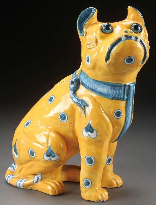 AN EMILE GALLE STYLE POTTERY PUG FIGURE, 20TH C: AN EMILE GALLE STYLE POTTERY PUG FIGURE, 20TH CENTURY. Modeled as a standing dog with lemon colored glaze and blue and white decoration and applied glass eyes. Inscribed "E. Galle Nancy" on base, heig