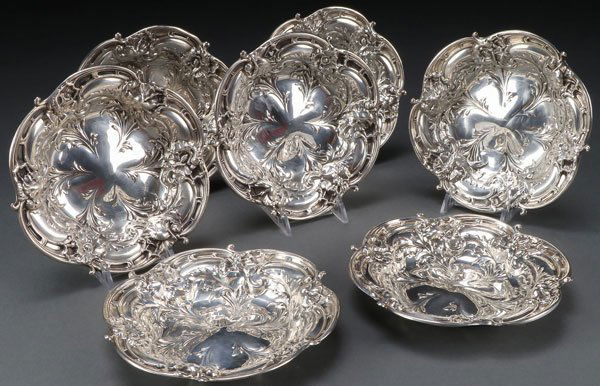 A SET OF SEVEN REED AND BARTON STERLING SILVER: A SET OF SEVEN REED AND BARTON STERLING SILVER BOWLS, 20TH CENTURY. With an embossed Art Nouveau design of poppies circling a scalloped rim. Stamped marks including pattern number “X276”. Diamete