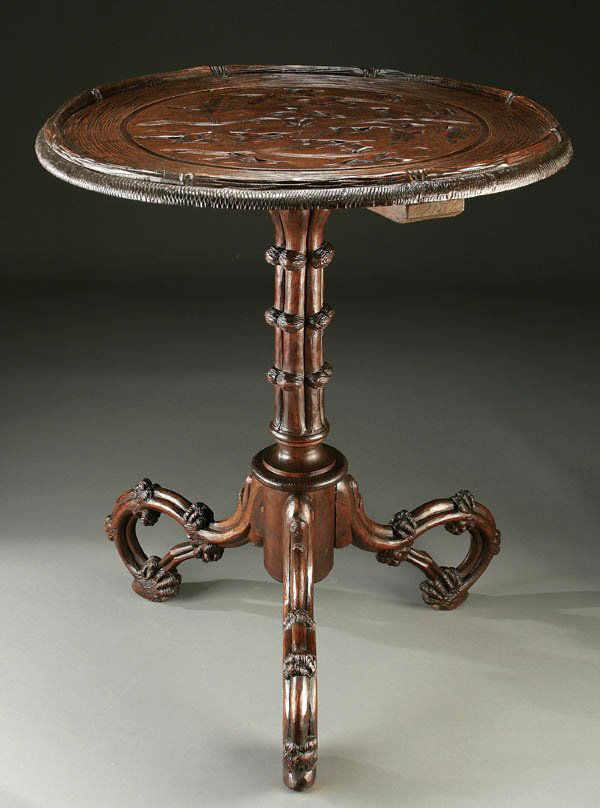 SWISS "BLACK FOREST" CARVED WOOD PARLOR TABLE cir: SWISS "BLACK FOREST" CARVED WOOD PARLOR TABLE circa 1900 rustic style with carved scrolling branches and intaglio foliate top. Height 30", diameter 24". Estimate $800-$1,200