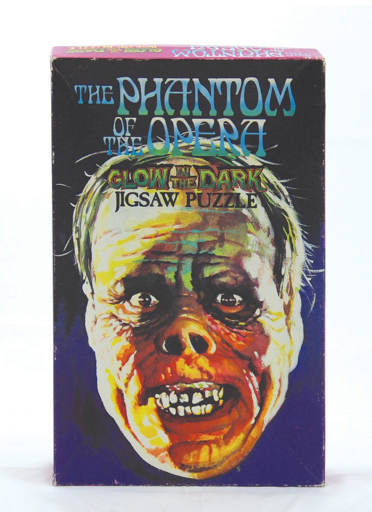 Phantom of the Opera Glow in the Dark Jigsaw: Phantom of the Opera Glow in the Dark Jigsaw Puzzle . Based on Lon Chaney's iconic make up design as the Phantom unmasked, this puzzle was produced by American Publishing Corp. in 1974. Includes a mat