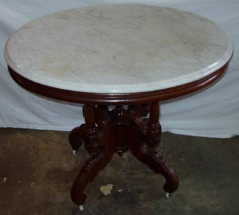 Antique Victorian Marble Top Parlor Table: Intricate carved base. Original porcelain castors. The wood is Walnut. Estimate of age: 1880's. 34"w x 26 1/2"d x 29 3/4"h. Custom Crating & Shipping Available.