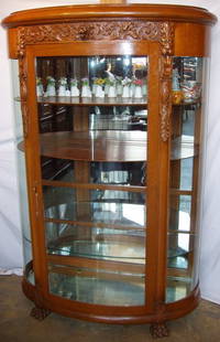 Griffin Glass Carved Clawfooted China Cabinet: Griffin Curve Glass Heavily Carved Clawfooted China Cabinet. Two original wood shelves, 2 glass and 1 mirrored shelf. Griffin escutcheon. Handle in brass with key. A couple of small scratches