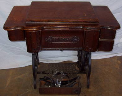 Antique Standard Sewing Machine: The cast bracket on left side has been broken. All parts are there. There are some surface scratches. Hidden drawers with carved side handles on the drawer. Sewing accessories. Size when