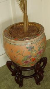 Oriental Planter with Stand: Heavily decorated with fish design inside planter. Signed on base. Good condition. Approx. size of the pot: 15" dia. x 12". With the stand: 22" tall Custom Crating, Packing Material & Shipping will