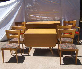 Heywood Wakefield Dining Room Set: Wheat color. The Buffet top shows some wear and a few water spots. Buffet - 54"x19"x34". 2 - armchairs - 25 3/4"x20"x34". 4 - side chairs - 20"x19"x33 1/4". 2 - leaves. Shows some wear. Drop leaf tabl
