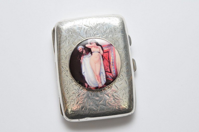 A silver cigarette case inset with later enamel style p: A silver cigarette case inset with later enamel style plaque of a 1920's Eastern nude maiden