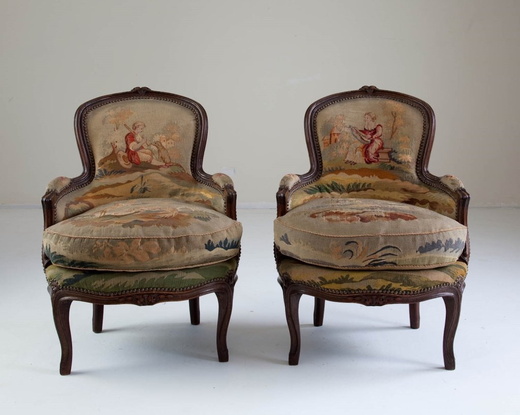 Pair of Aubusson Tapestry Arm Chairs: late 19th century, French Louis XV style, carved walnut with Aubusson tapestry fragment of birds and people upholstered seats, backs, sides, cushion and arm rests. Very good to excellent condition. he