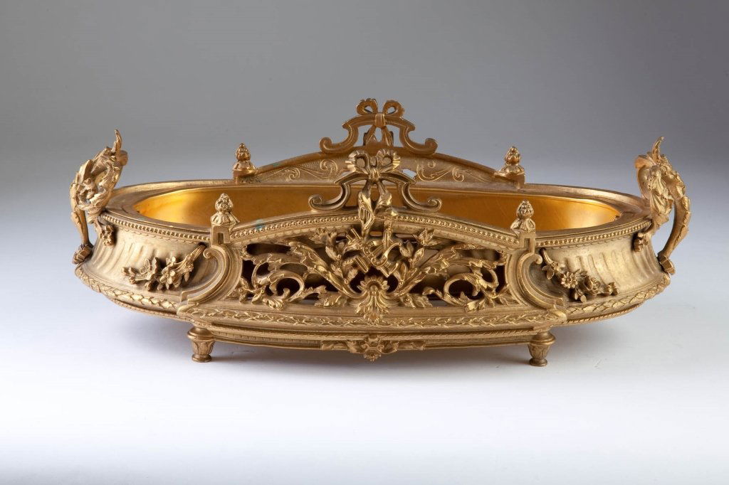 French Bronze Dore Centerpiece: 19th century Oval form, winged figural handles, sides with open relief harps and foliage topped with ribbons, on toupee feet. Excellent condition. height 6in; width 16in; depth 8in
