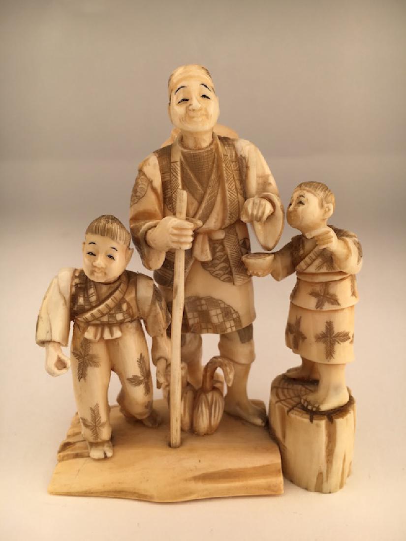 A carved figurine of a man with two young children (1 of 3)