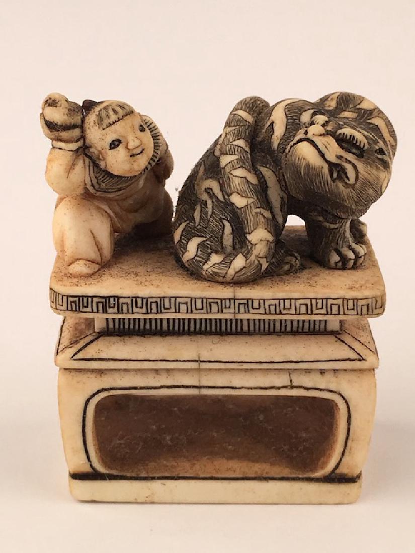 A carved Netsuke figure of a man with a large animal. (1 of 7)