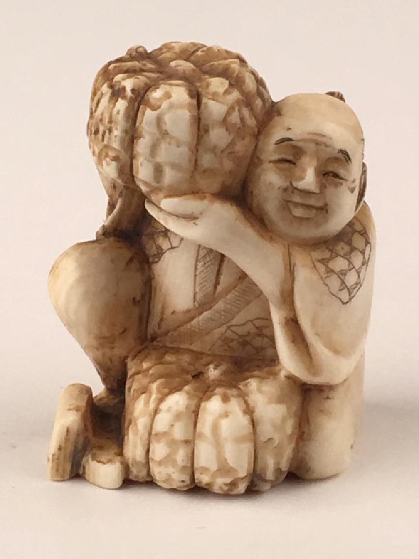 A carved Netsuke figure of a man holding a melon over (1 of 4)