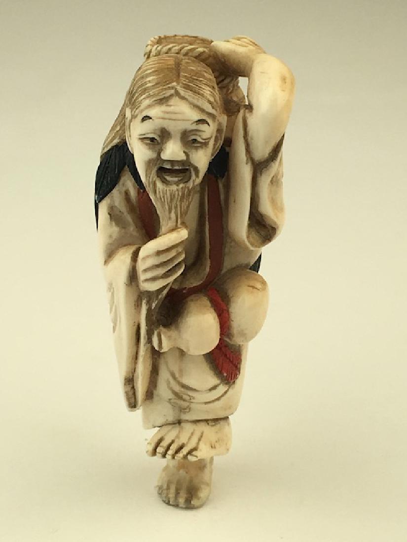 Carved netsuke figure of a man tugging at his beard. (1 of 7)