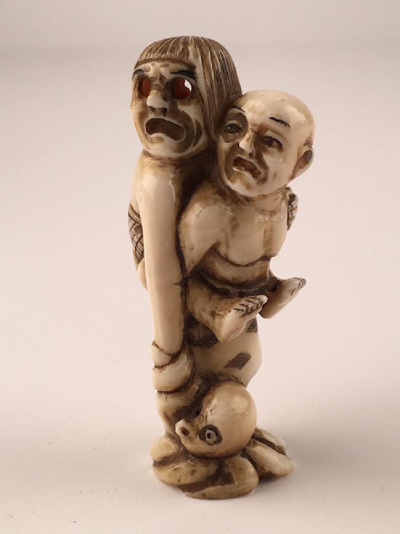Carved Japanese Netsuke figure of a man with a lady (1 of 6)