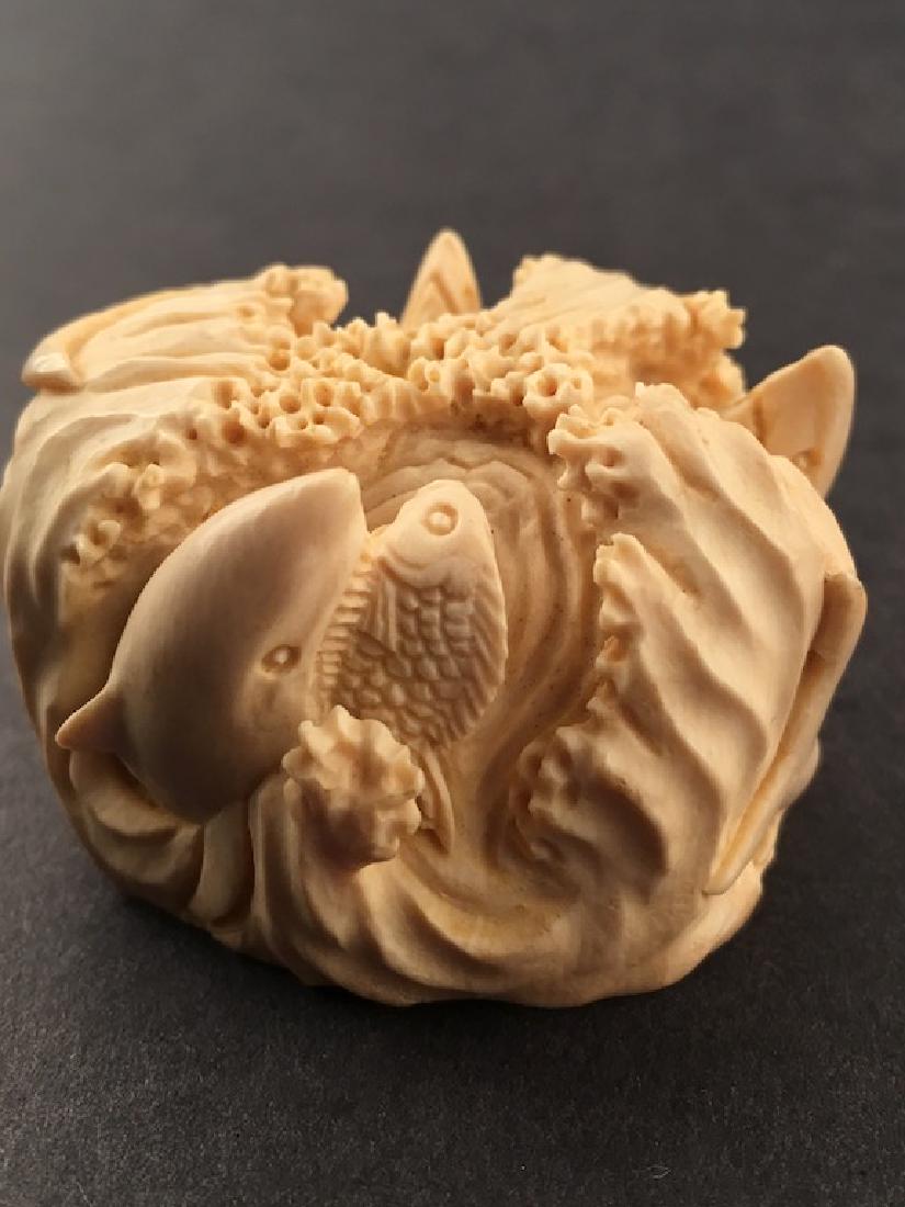 Carved figure of a group of swimming dolphins and fish. (1 of 6)