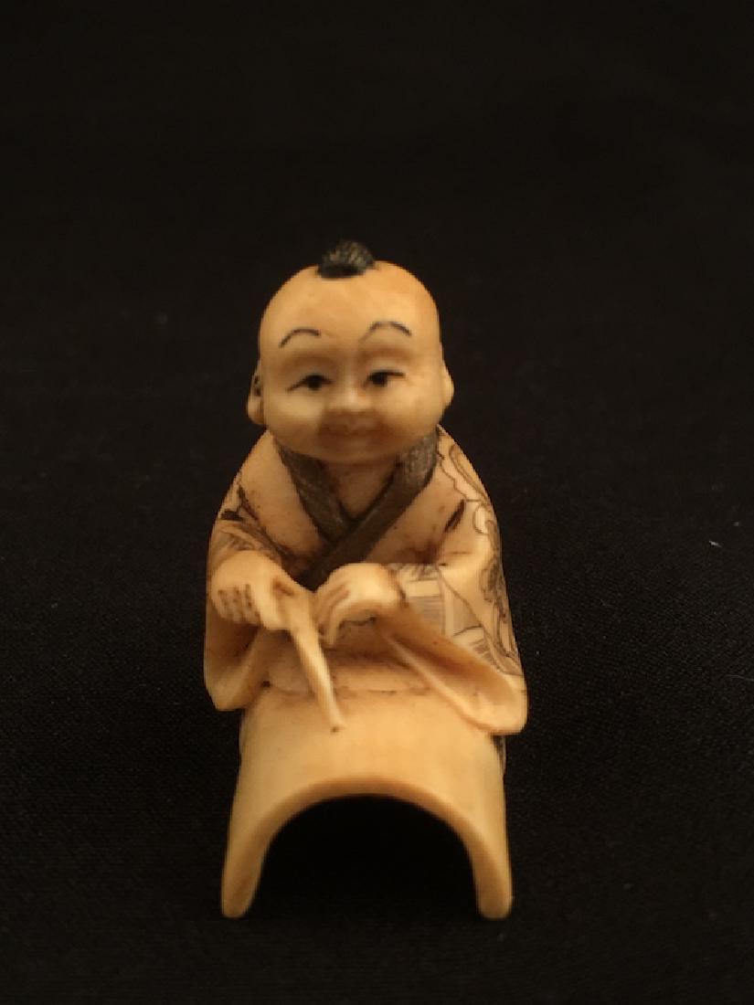 Antique carved Netsuke figure of a child sitting on a (1 of 5)