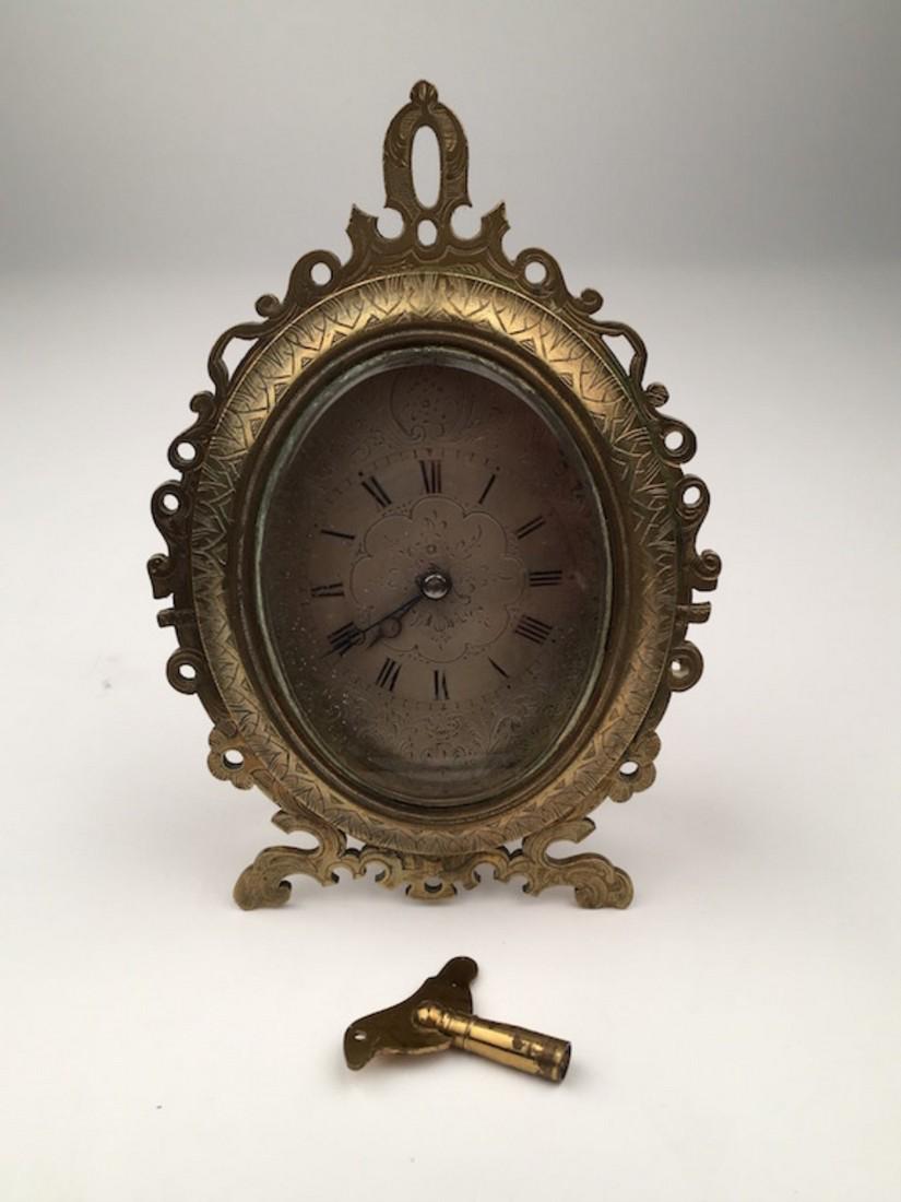 A strutt clock after those of Thomas Cole with a silver: A strutt clock after those of Thomas Cole with a silver facehand dial with painted Roman numerals.The oval case is with a pierced brassfront and a easle back.4 inches wide x 5 inches high.3317 $ 1,650