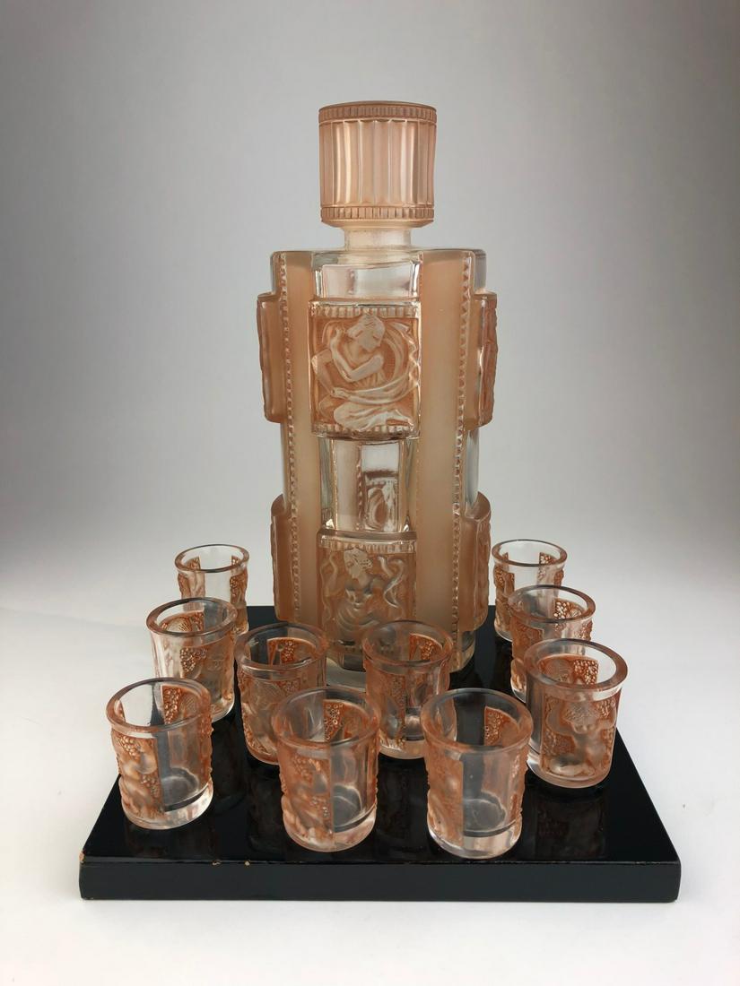 Rene Lalique decanter and 10 shot glasses in clear and: Rene Lalique decanter and 10 shot glasses in clear and frosty glass with a sepia patina. Signed "R. Lalique France" in script. Height of decanter 8 7/8 inches. Height of glasses 1 9/16 inches.