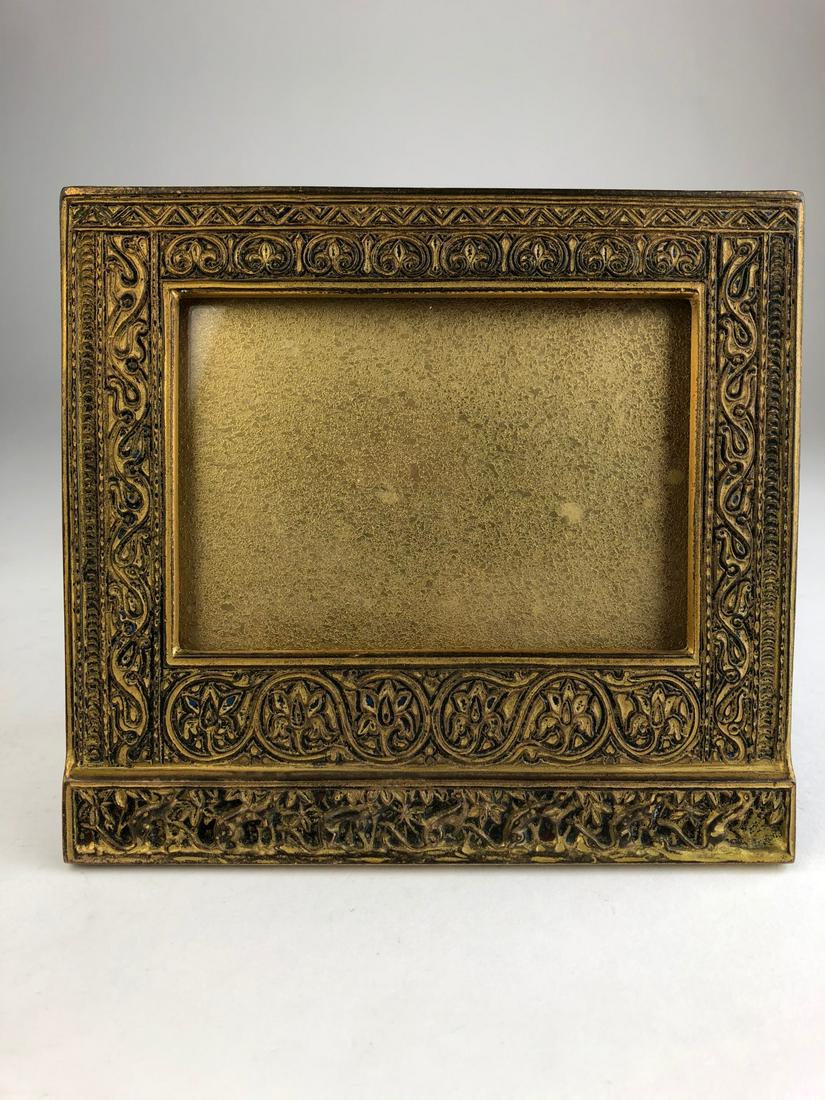 Tiffany Studios bronze photo frame in the Venetian: Tiffany Studios bronze photo frame in the Venetian pattern. Stamped Tiffany Studios New York 1848. Height 6 inches. Width 6 1/2 inches.