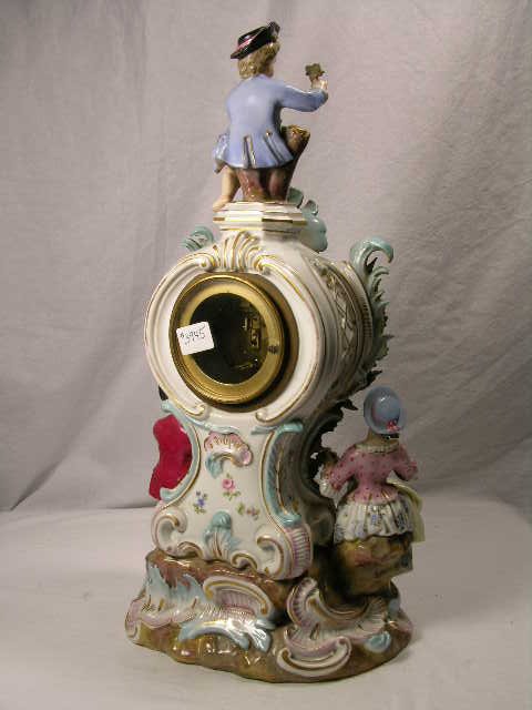 PORCELAIN MANTEL CLOCK WITH FOUR FIGURINES. CHIP - 2