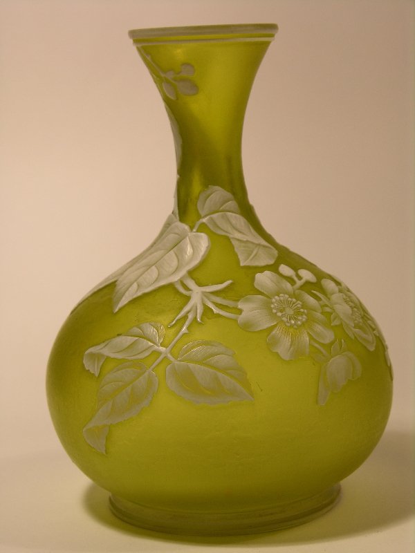 WEBB (ENGLISH) CAMEO VASE.: WEBB (ENGLISH) CAMEO VASE.CITRON COLORED VASE WITH A WHITE OVERLAY CAMEO DECORATION OF SUNFLOWERS, LEAVES AND STEMS WITH TWO BUTTERFLIES.HEIGHT 5 3/4". CIRCA 1890.