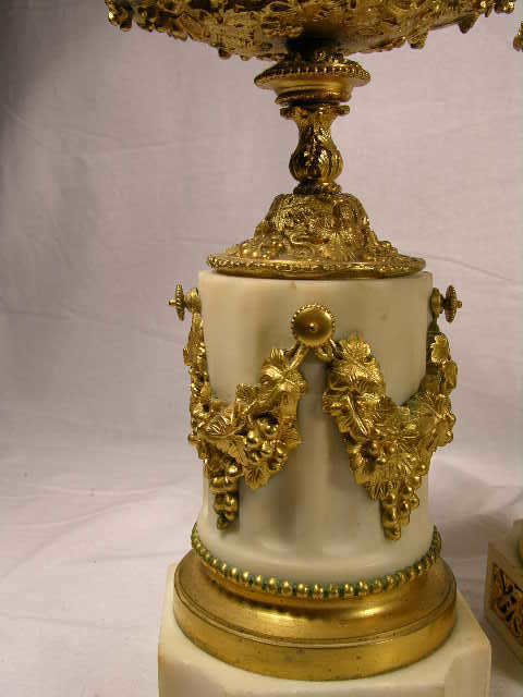 A PAIR OF WHITE MARBLE AND GOLD DORE TAZZAS.: A PAIR OF WHITE MARBLE AND GOLD DORE TAZZAS. VERY ELABORATE SCROLLS OF GRAPES AND LEAVES. CIRCA 1880. OVERALL HEIGHT 9 3/4".